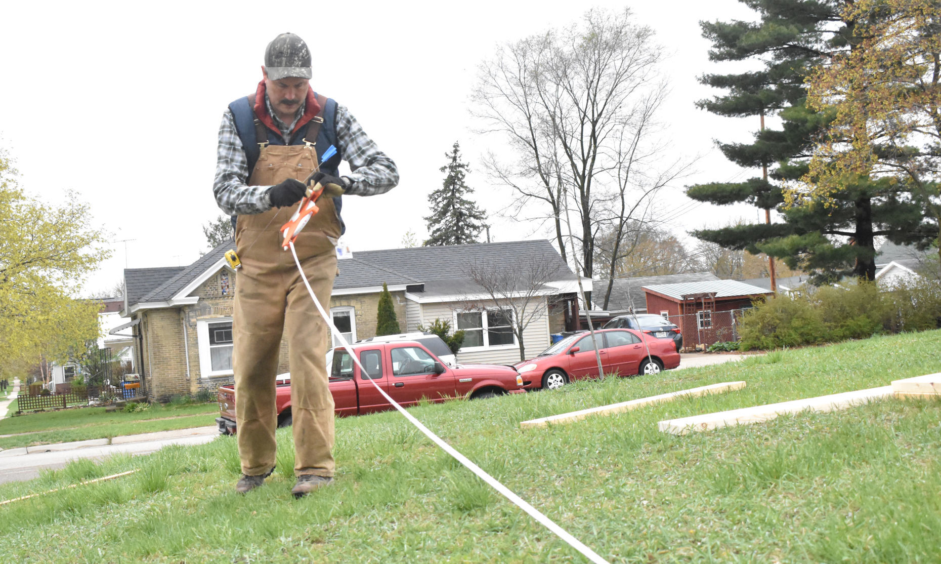 George Koepp measures fence length for Portage garden